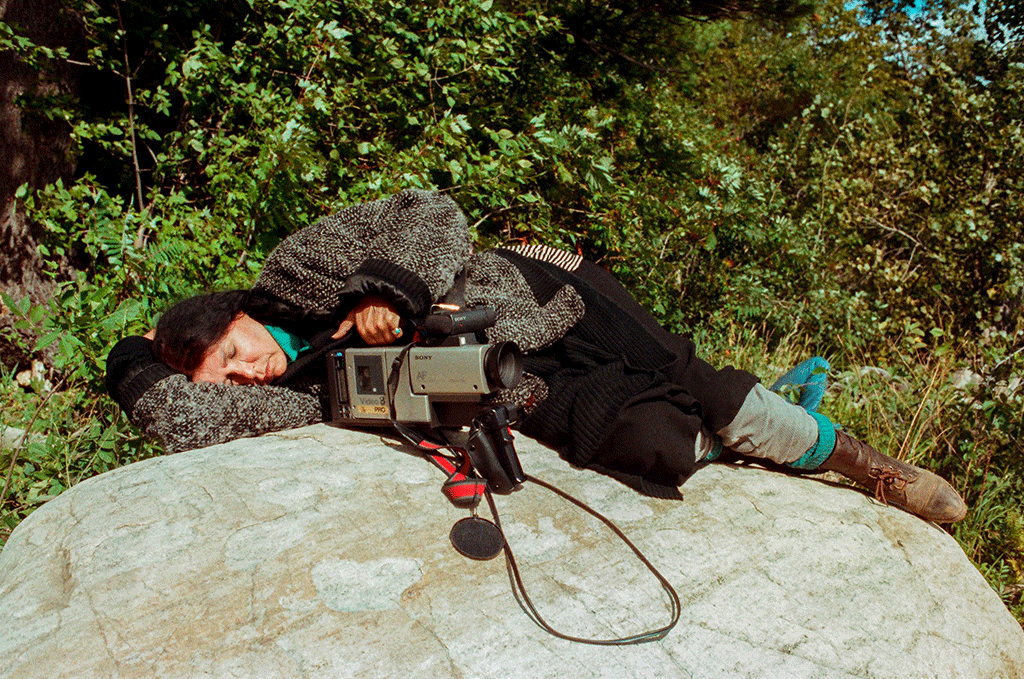 Alanis Obomsawin rests on a rock beside the Lake of Two Mountains, Kanehsatake, 1990. / Photo: John Kenney 