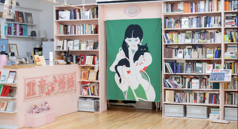 Interior of Accent Sisters space with bookshelves and a portrait of a young girl holding a cat.
